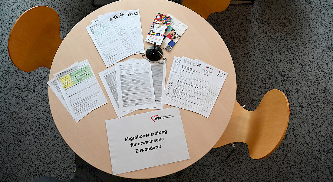 Auf einem runden Tisch liegen verschiedene Informationszettel und Flyer