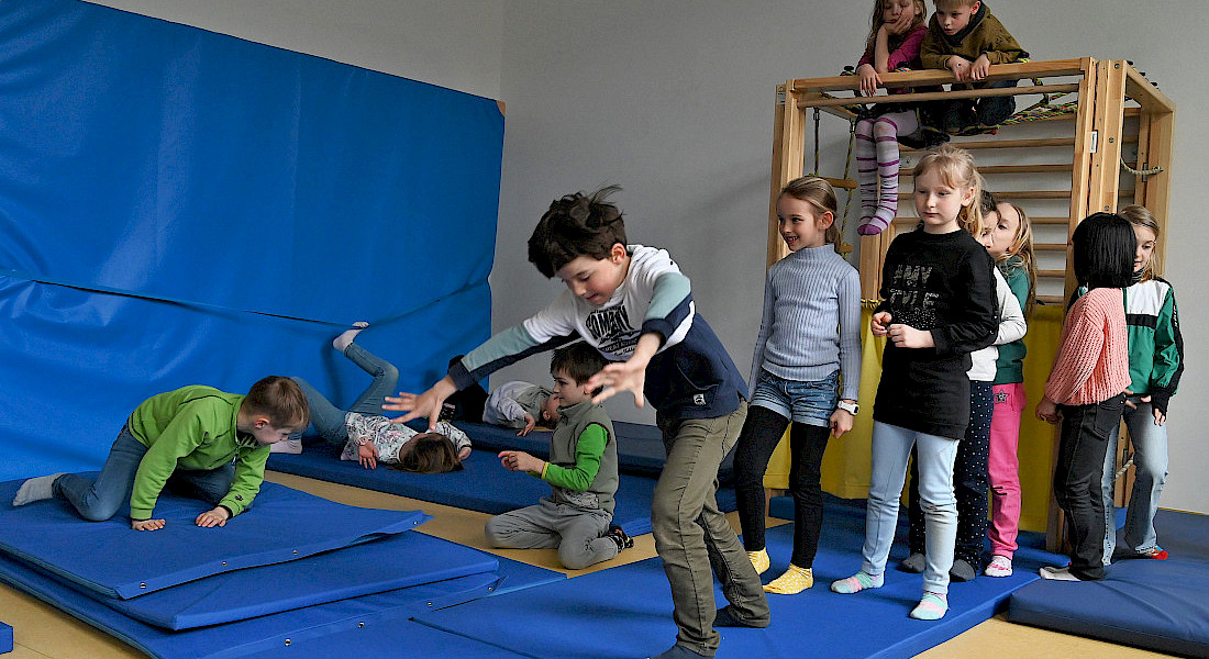Kinder machen Turnübungen im Bewegungsraum.