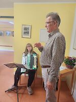 Akkordeonspielerin und Person hält Rede
