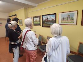 Personen in Raum mit Bilder-Ausstellung