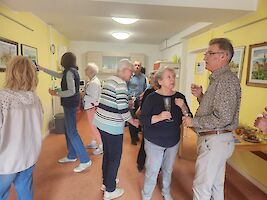 Personen in Raum mit Bilder-Ausstellung