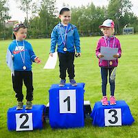 Drei Kinder stehen auf dem Siegerpodest