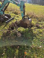 Ein Bagger hebt ein Loch aus.