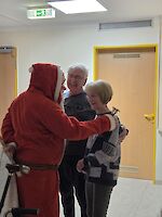 Weihnachtsmann im Gespräch mit zwei Personen