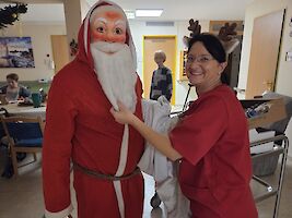 Weihnachtsmann und Person mit Rentierdeko