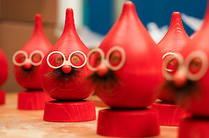 Rote Räucherfiguren aus rot angestrichenem Holz. Sie haben eine kleine Runde Nase, eine Brille und ein Bärtchen