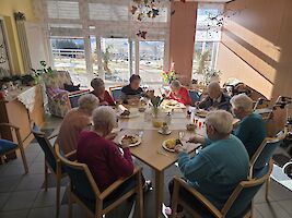 Gruppe sitzt um einen großen Tisch beim Mittagessen
