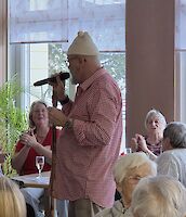 Musiker laufen durch Speisesaal der mit vielen Personen besetzt ist.