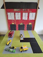 Gebastelte Feuerwache aus Pappe und Spielzeug-Fahrzeuge