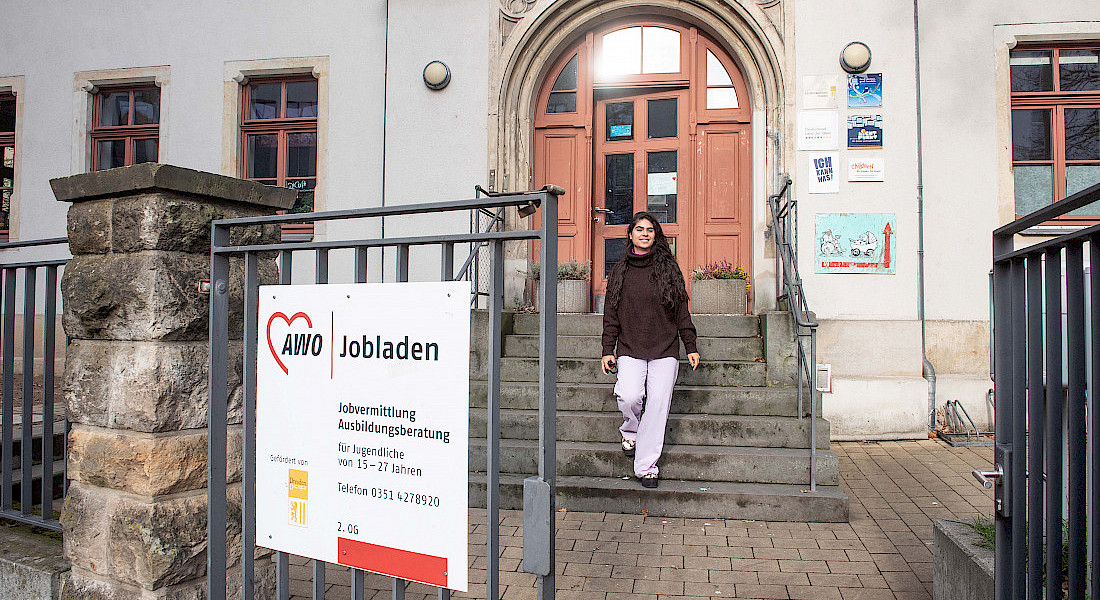 Eine Person kommt aus dem AWO Jobladen die Treppe hinunter.