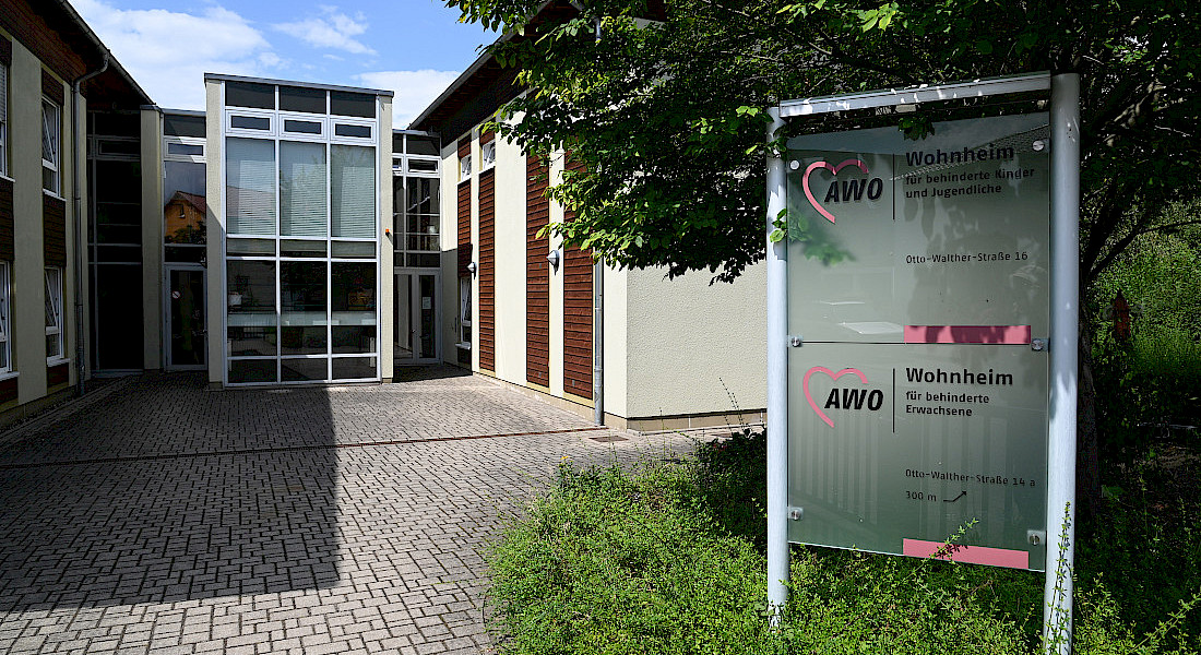 Außenansicht von Gebäude mit Infotafel.