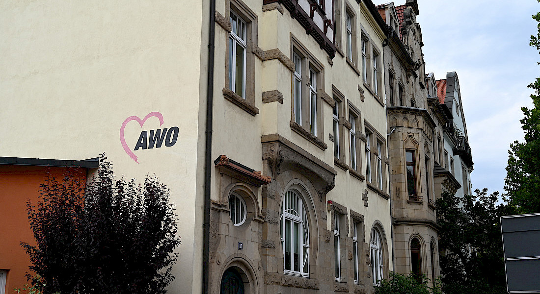 Außenansicht eines historischen Gebäudes mit AWO-Logo an der Fassade.